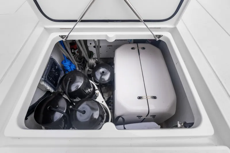 Slide: The Image of Open storage compartment on 2024 Intrepid 41 Valor boat, featuring ropes and fenders. - 36