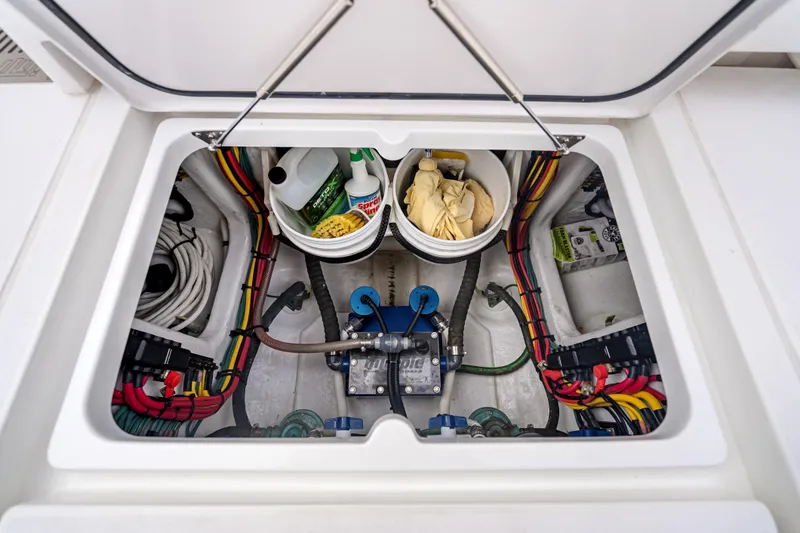 Slide: The Image of 2024 Intrepid 41 Valor boat storage compartment with cleaning supplies and wiring. - 38