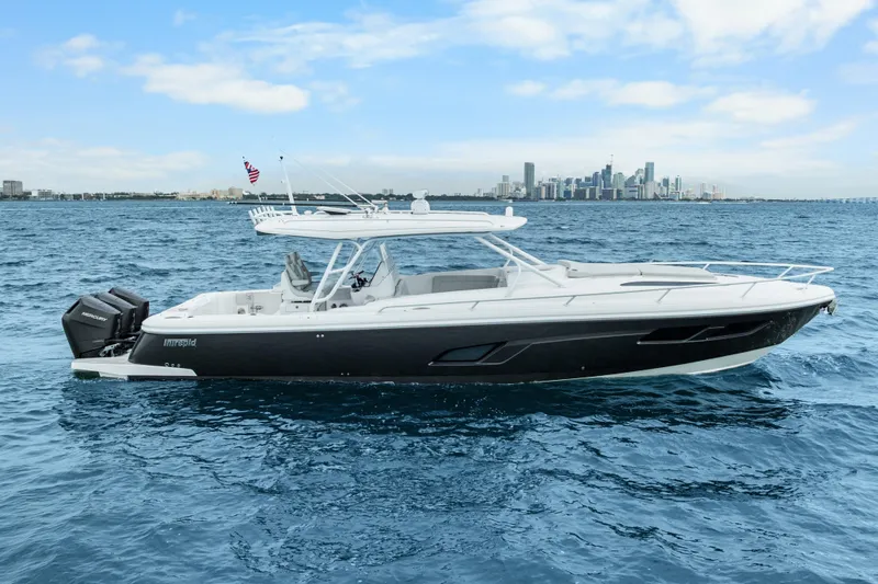 Slide: The Image of 2024 Intrepid 41 Valor boat cruising on open water with city skyline backdrop. - 7