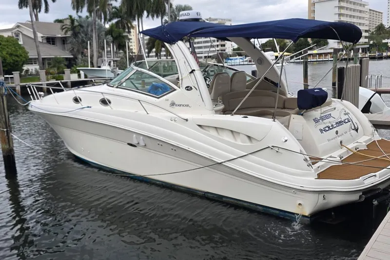 The Image of 2004 Sea Ray 340 Sundancer docked by palm trees and waterfront buildings. - 0