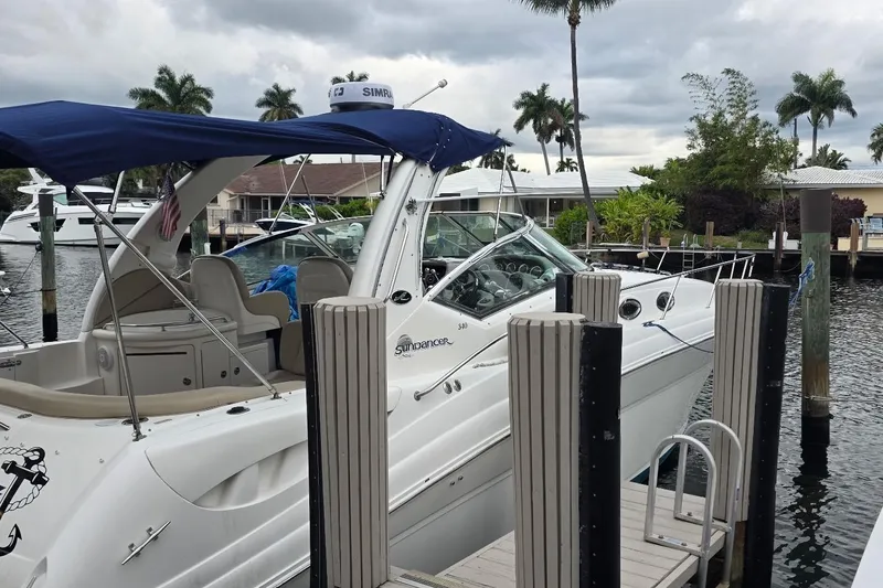 Slide: The Image of 2004 Sea Ray 340 Sundancer docked in a sunny marina with palm trees. - 1