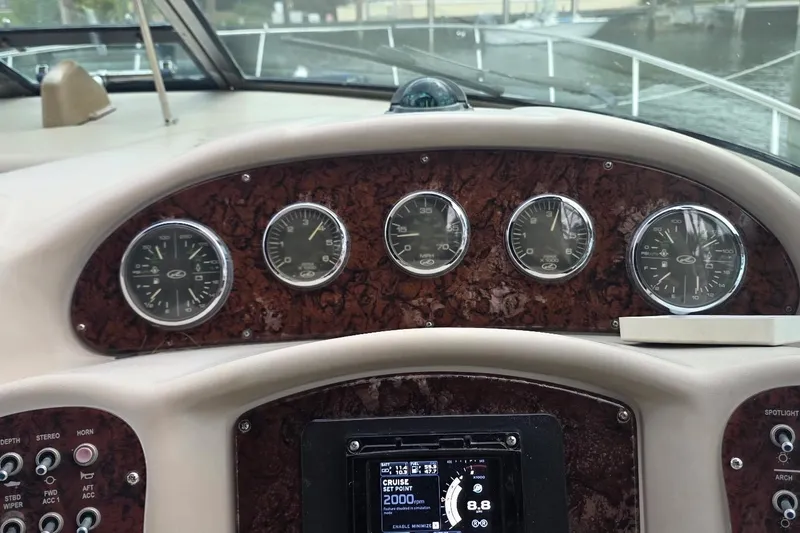 Slide: The Image of 2004 Sea Ray 340 Sundancer yacht with spacious seating, docked by palm trees and waterfront buildings. - 10