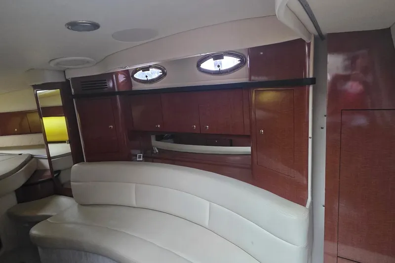 Slide: The Image of 2004 Sea Ray 340 Sundancer interior with plush seating and wooden deck, docked at marina. - 14