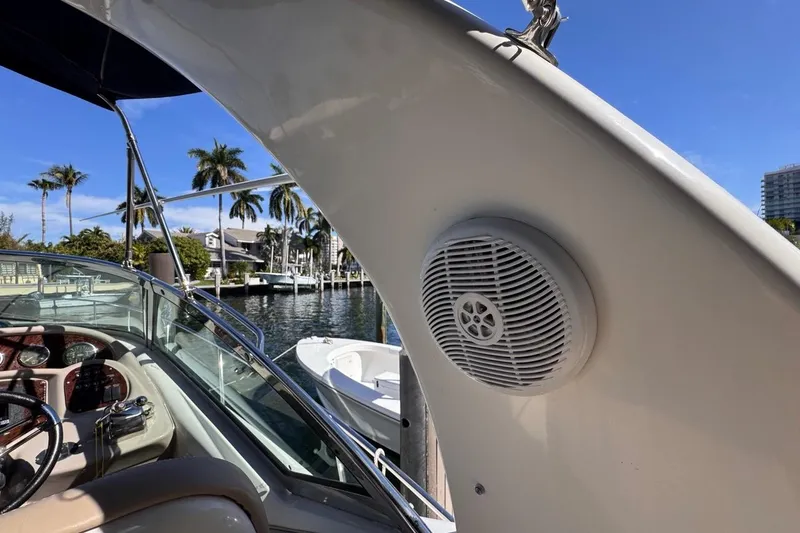 Slide: The Image of 2004 Sea Ray 340 Sundancer boat with speaker, docked near palm trees and waterfront homes. - 26