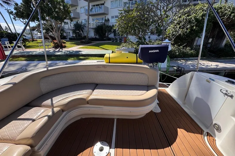 Slide: The Image of 2004 Sea Ray 340 Sundancer boat interior with cushioned seating and wooden deck. - 27