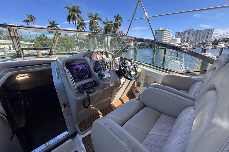 Slide: The Image of 2004 Sea Ray 340 Sundancer cockpit with modern controls, docked near palm trees and buildings. - 31