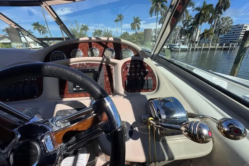 Slide: The Image of 2004 Sea Ray 340 Sundancer helm with steering wheel and control panel, dockside view. - 34