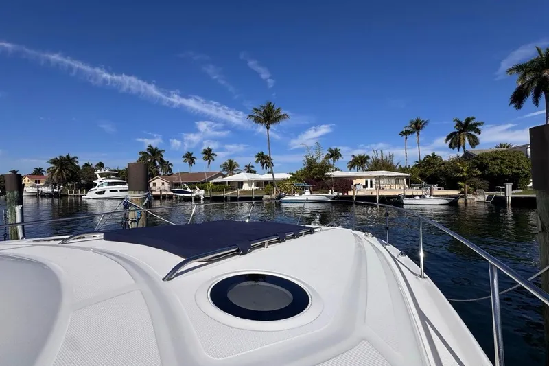 Slide: The Image of 2004 Sea Ray 340 Sundancer yacht docked in a scenic waterfront area with palm trees. - 44