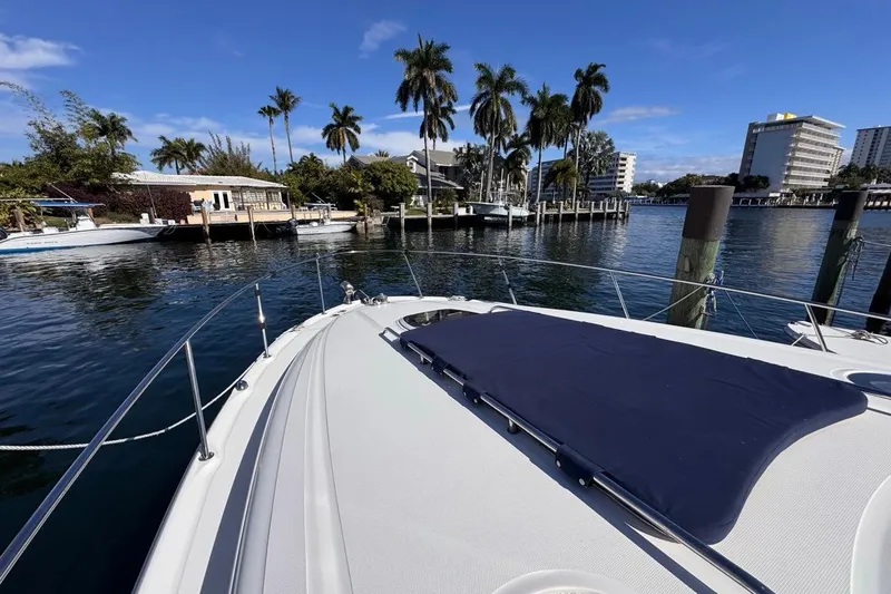 Slide: The Image of 2004 Sea Ray 340 Sundancer yacht docked near palm trees and waterfront buildings. - 45