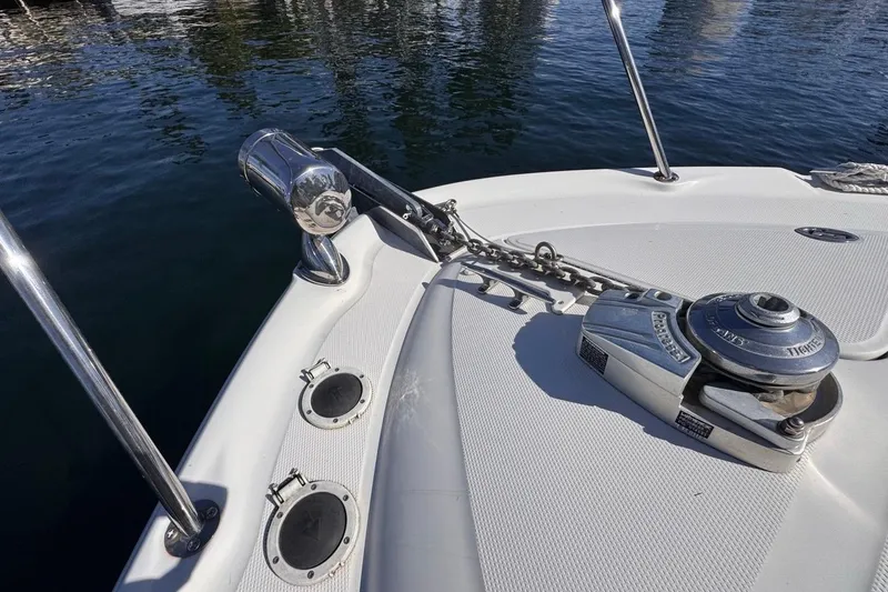Slide: The Image of 2004 Sea Ray 340 Sundancer boat anchor and chain on deck by the water. - 49