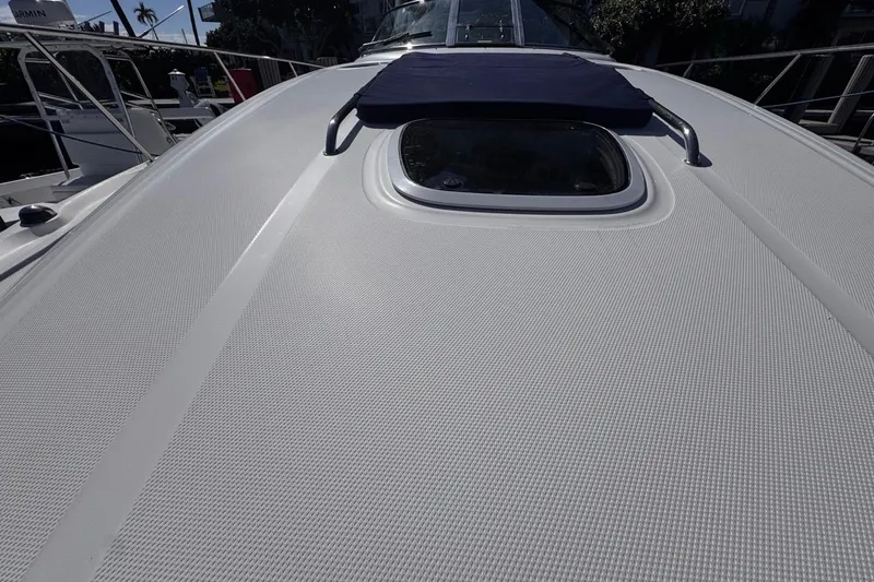 Slide: The Image of 2004 Sea Ray 340 Sundancer boat deck with textured surface and hatch. - 51