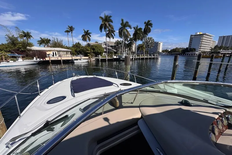 Slide: The Image of 2004 Sea Ray 340 Sundancer yacht docked by palm trees and waterfront buildings. - 53
