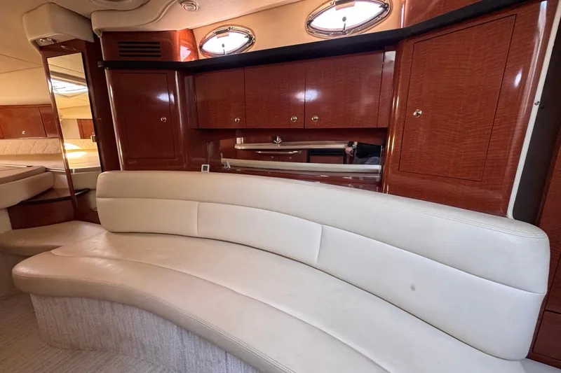 Slide: The Image of Luxurious interior of 2004 Sea Ray 340 Sundancer with curved seating and wooden cabinetry. - 68