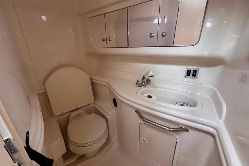 Slide: The Image of 2004 Sea Ray 340 Sundancer bathroom with toilet, sink, and storage cabinets. - 75