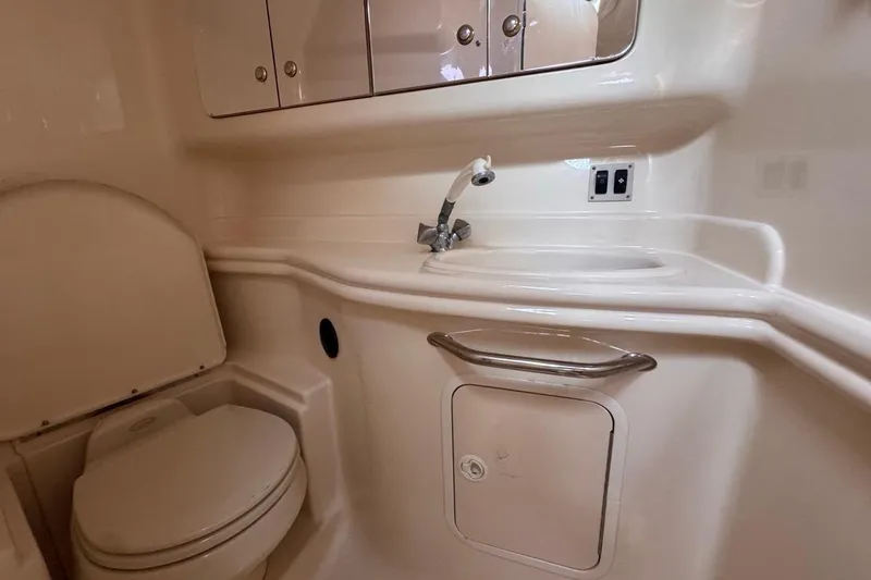 Slide: The Image of 2004 Sea Ray 340 Sundancer bathroom with sink, toilet, and storage cabinets. - 76