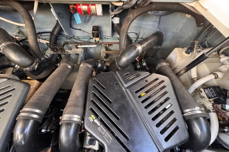 Slide: The Image of Engine compartment of a 2004 Sea Ray 340 Sundancer boat, showcasing hoses and components. - 81