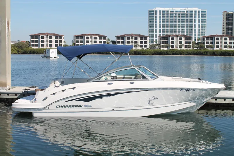 Slide: The Image of 2015 Chaparral 224 Sunesta boat docked on calm water with buildings in background. - 15