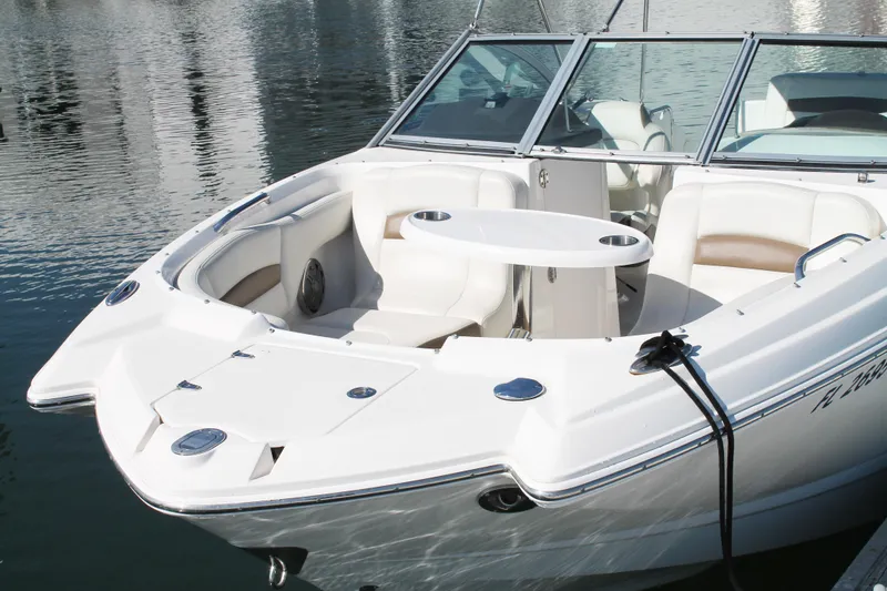 Slide: The Image of 2015 Chaparral 224 Sunesta boat with white seating and table on calm water. - 19