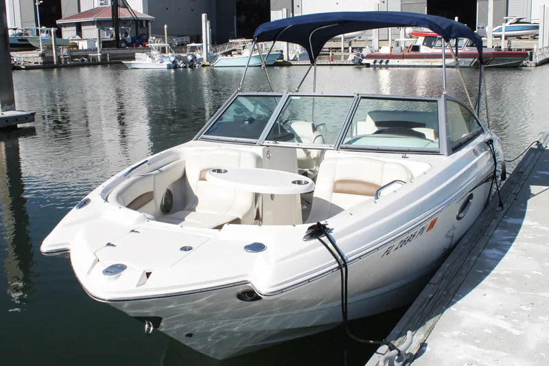 Slide: The Image of 2015 Chaparral 224 Sunesta boat docked at marina with blue canopy. - 20