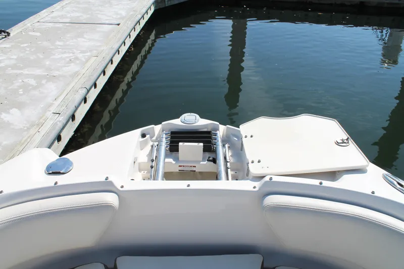 Slide: The Image of 2015 Chaparral 224 Sunesta boat at dock, featuring open storage compartment. - 25