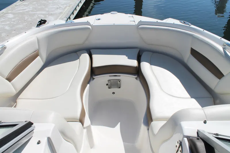 Slide: The Image of 2015 Chaparral 224 Sunesta boat interior with white seating and dockside view. - 26