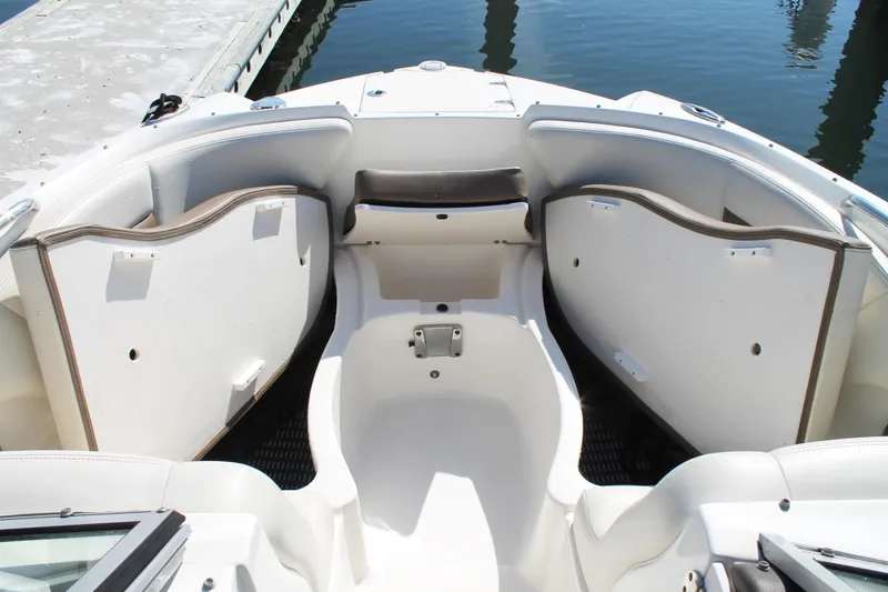 Slide: The Image of 2015 Chaparral 224 Sunesta boat interior with open storage compartments at dock. - 27