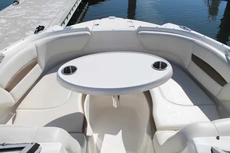 Slide: The Image of 2015 Chaparral 224 Sunesta boat interior with seating and table, docked by the water. - 28