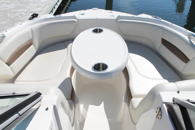Slide: The Image of 2015 Chaparral 224 Sunesta boat interior with seating and table, docked by the water. - 29