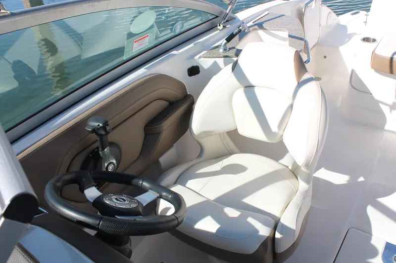 Slide: The Image of 2015 Chaparral 224 Sunesta boat cockpit with steering wheel and white seat. - 36