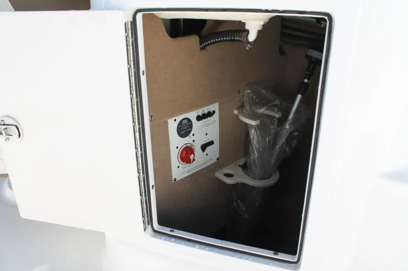 Slide: The Image of 2015 Chaparral 224 Sunesta storage compartment with control panel and equipment holders. - 44
