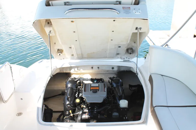 Slide: The Image of 2015 Chaparral 224 Sunesta boat engine compartment with open hatch, docked on water. - 49