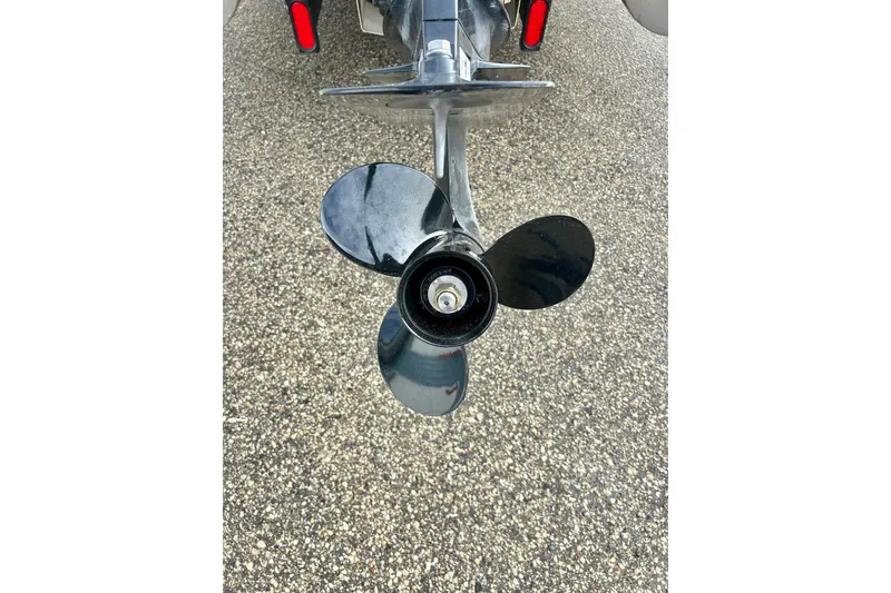 Slide: The Image of Propeller of 2010 Sun Tracker Party Barge 20 Classic Series on gravel surface. - 9