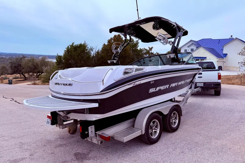 Slide: The Image of 2010 Nautique Super Air Nautique 210 boat on trailer, parked outdoors. - 11