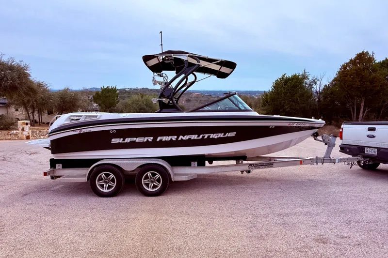 Slide: The Image of 2010 Nautique Super Air Nautique 210 boat on trailer, parked outdoors. - 12