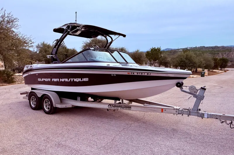 Slide: The Image of 2010 Nautique Super Air Nautique 210 boat docked in covered marina. - 13