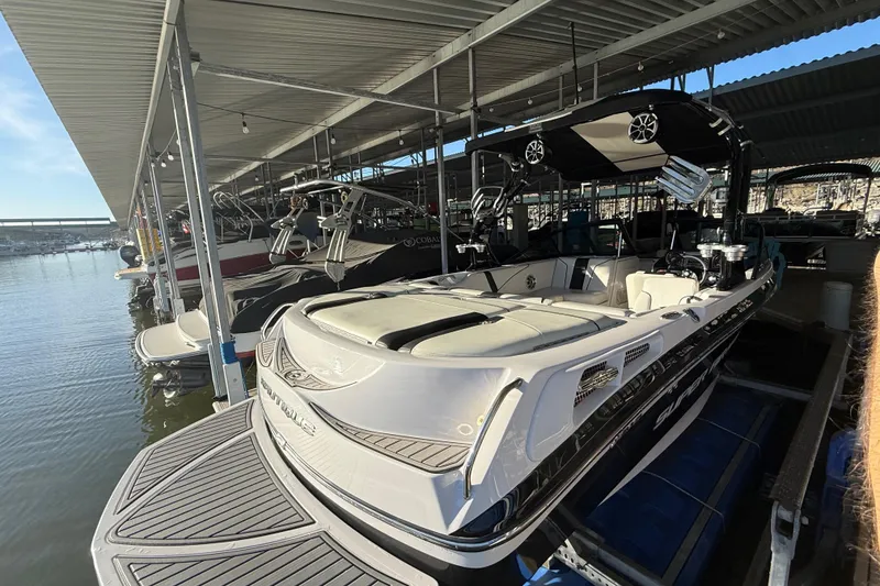 Slide: The Image of 2010 Nautique Super Air Nautique 210 boat interior with seating and wakeboard racks. - 16