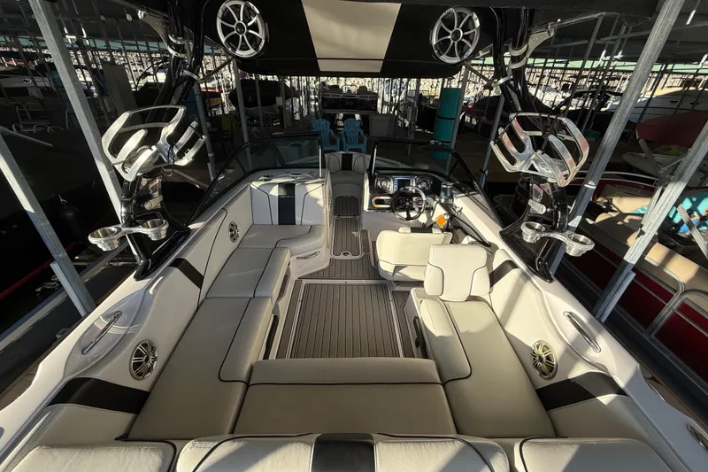 Slide: The Image of 2010 Nautique Super Air Nautique 210 boat interior, docked, with sleek seating and modern design. - 18