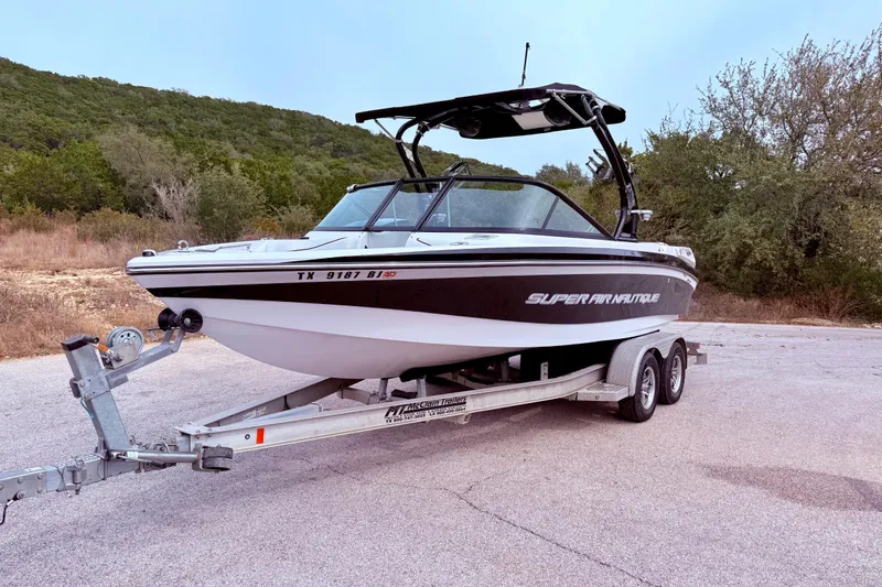 Slide: The Image of 2010 Nautique Super Air Nautique 210 boat on trailer, parked outdoors. - 7