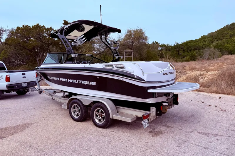 Slide: The Image of 2010 Nautique Super Air Nautique 210 boat on trailer, parked outdoors. - 9