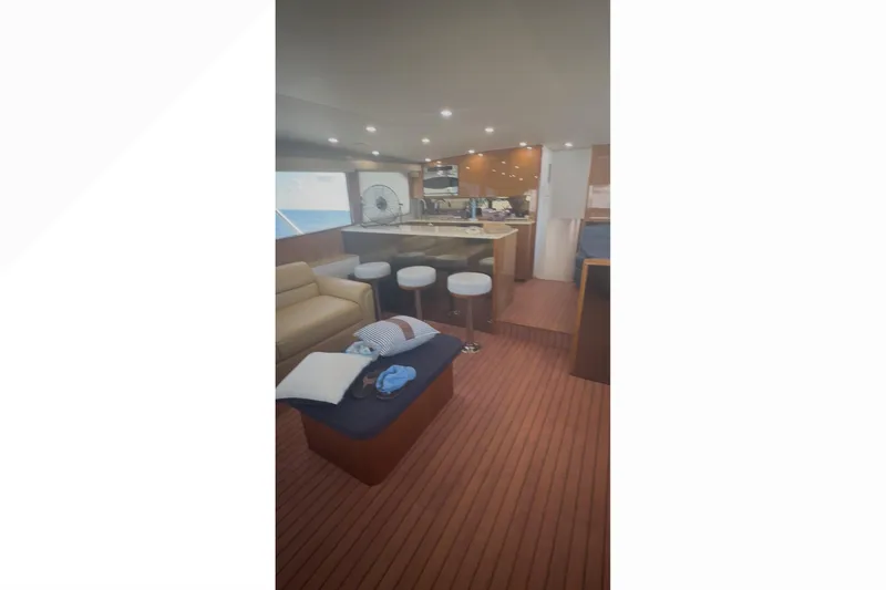 Slide: The Image of Interior of 2003 Viking 65 Convertible yacht with modern seating and kitchen area. - 12