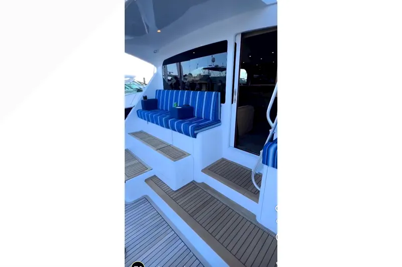 Slide: The Image of 2003 Viking 65 Convertible yacht with striped seating and wooden steps. - 14