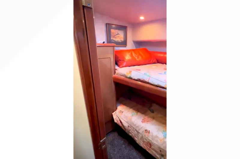 Slide: The Image of 2003 Viking 65 Convertible yacht cabin with bunk beds and cozy decor. - 15