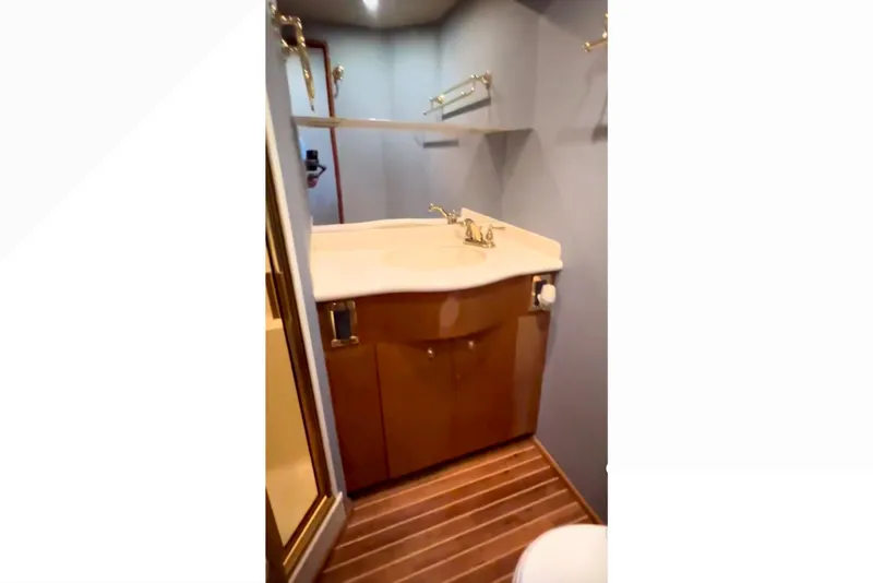 Slide: The Image of Bathroom interior of 2003 Viking 65 Convertible yacht with wooden flooring and modern fixtures. - 17