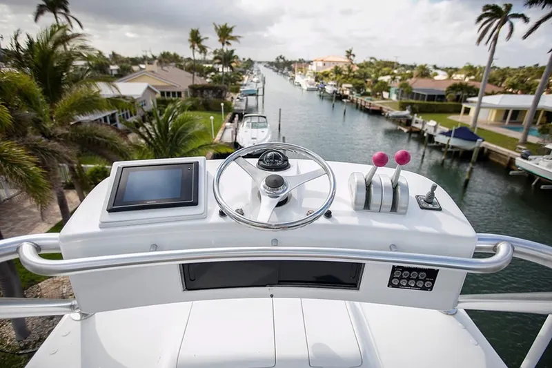 Slide: The Image of Helm of 2003 Viking 65 Convertible yacht overlooking a scenic canal. - 18