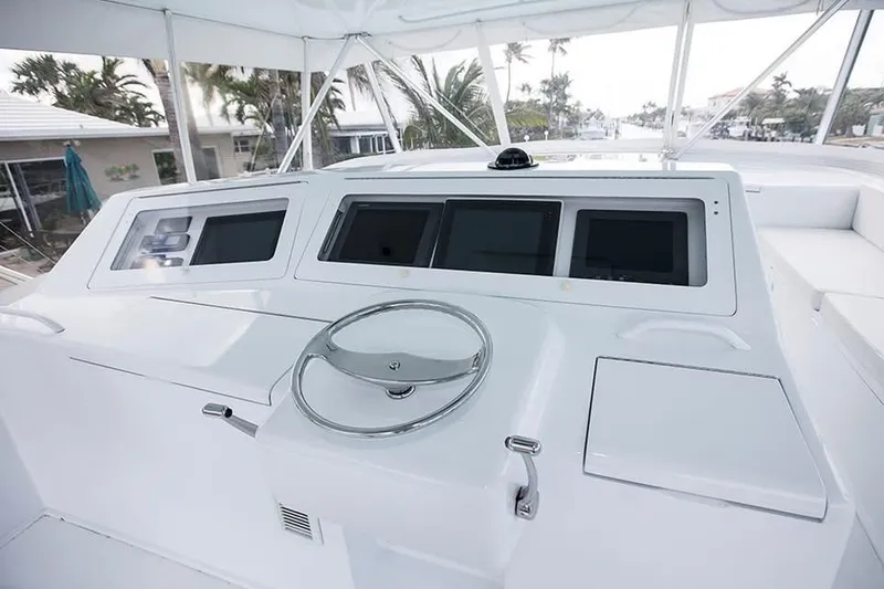 Slide: The Image of 2003 Viking 65 Convertible yacht helm with modern navigation displays and steering wheel. - 19