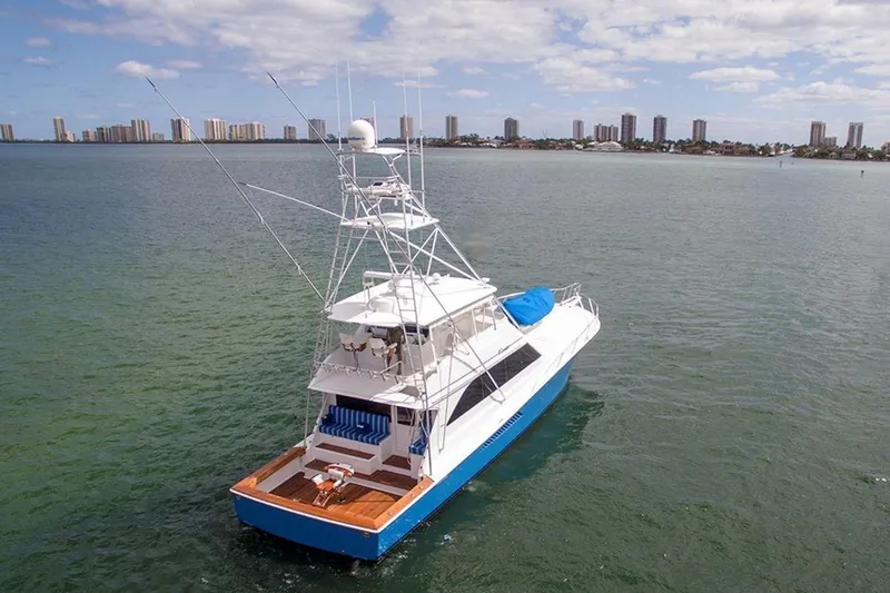 Slide: The Image of 2003 Viking 65 Convertible yacht on calm water with city skyline in background. - 3