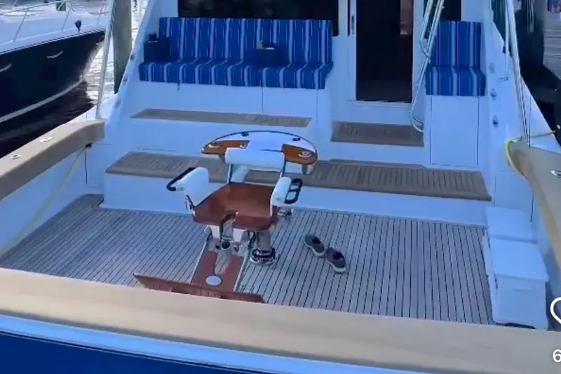 Slide: The Image of 2003 Viking 65 Convertible yacht deck with striped seating and fishing chair. - 7