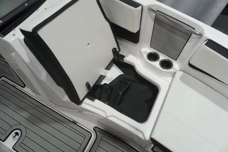 Slide: The Image of 2024 Yamaha Boats 222SD interior storage compartment with cup holders and seating. - 14