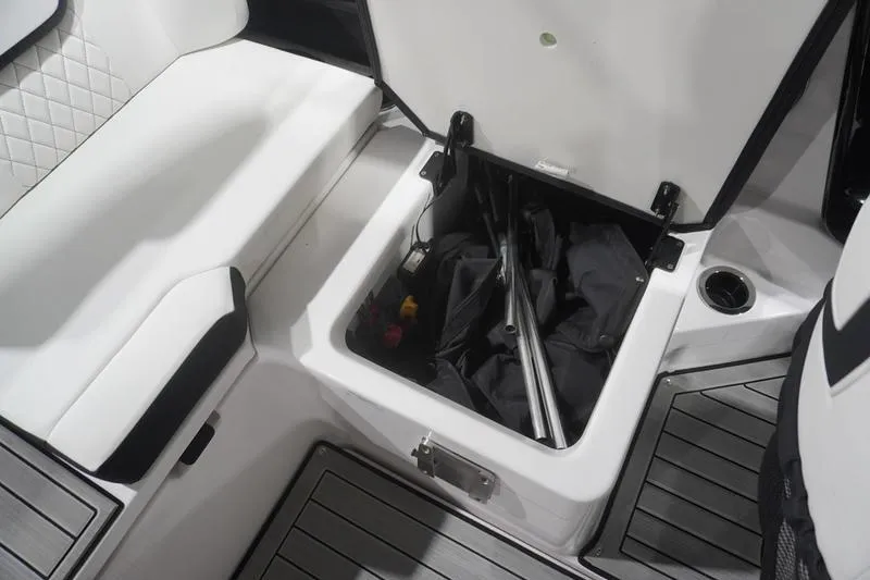 Slide: The Image of 2024 Yamaha Boats 222SD storage compartment with open lid, revealing interior contents. - 30