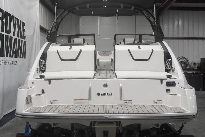 Slide: The Image of 2024 Yamaha Boats 222SD, rear view in a showroom, showcasing sleek design and seating. - 5